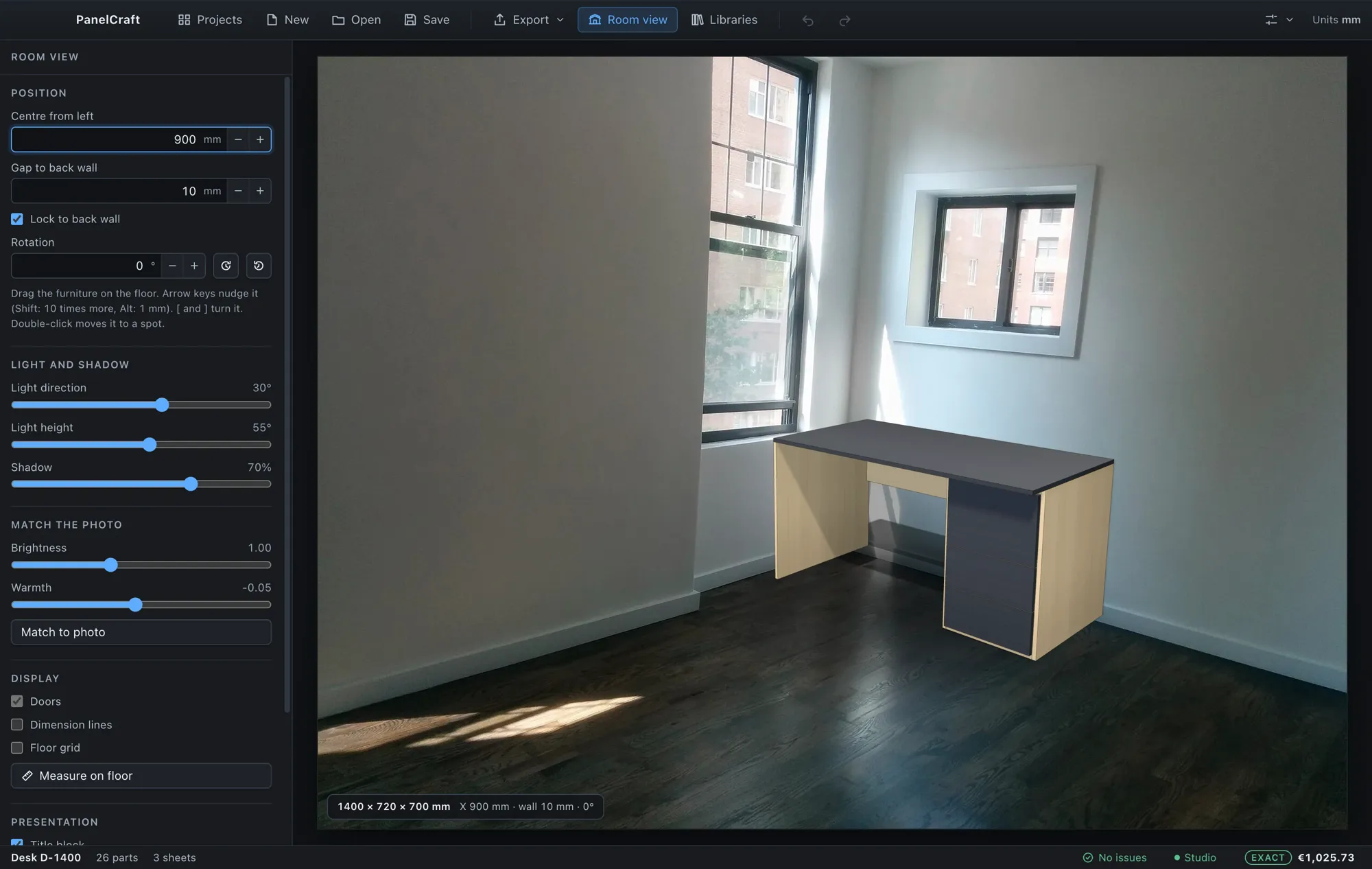 A desk placed on the floor of a room photograph with position and light controls.
